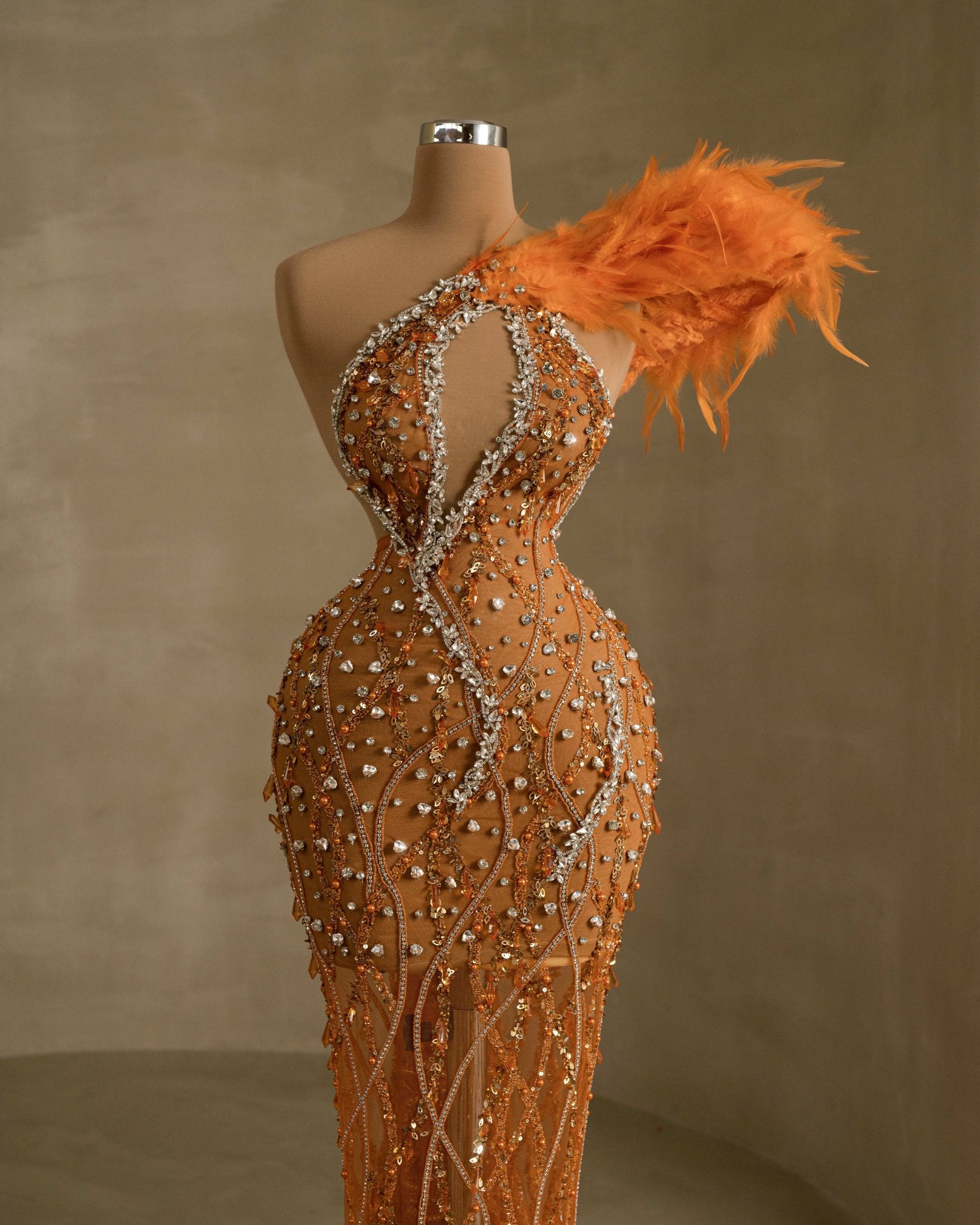 Glamorous gown featuring intricate stone embellishments and graceful feather detailing