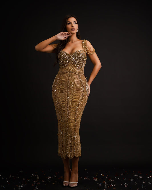 A stunning maxi-length gold dress featuring elegant tassels and luxurious accents.