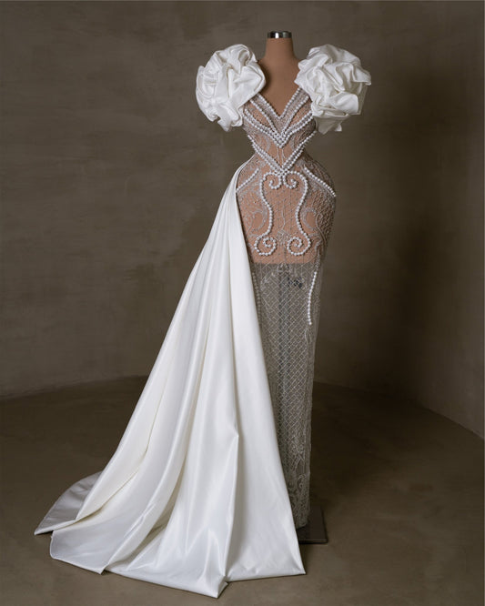 Pearl-embellished lace bridal dress with satin details.