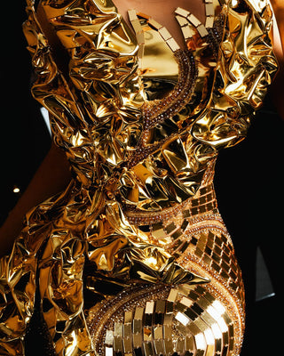 Close-up of detailed gold lace and mirrorwork on dress
