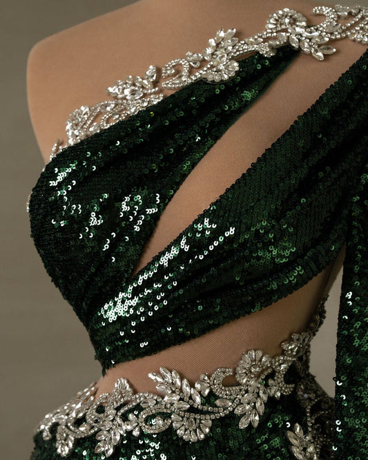 Close-up of the bodice on a green sequin dress, highlighting intricate silver embellishments