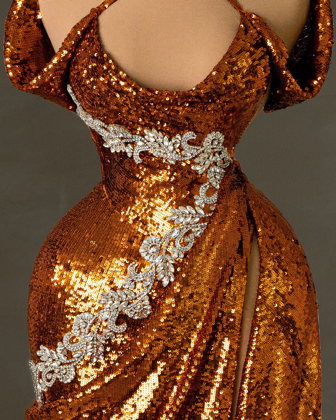 Close-up of the bodice on an orange sequin dress, showcasing intricate silver embellishments
