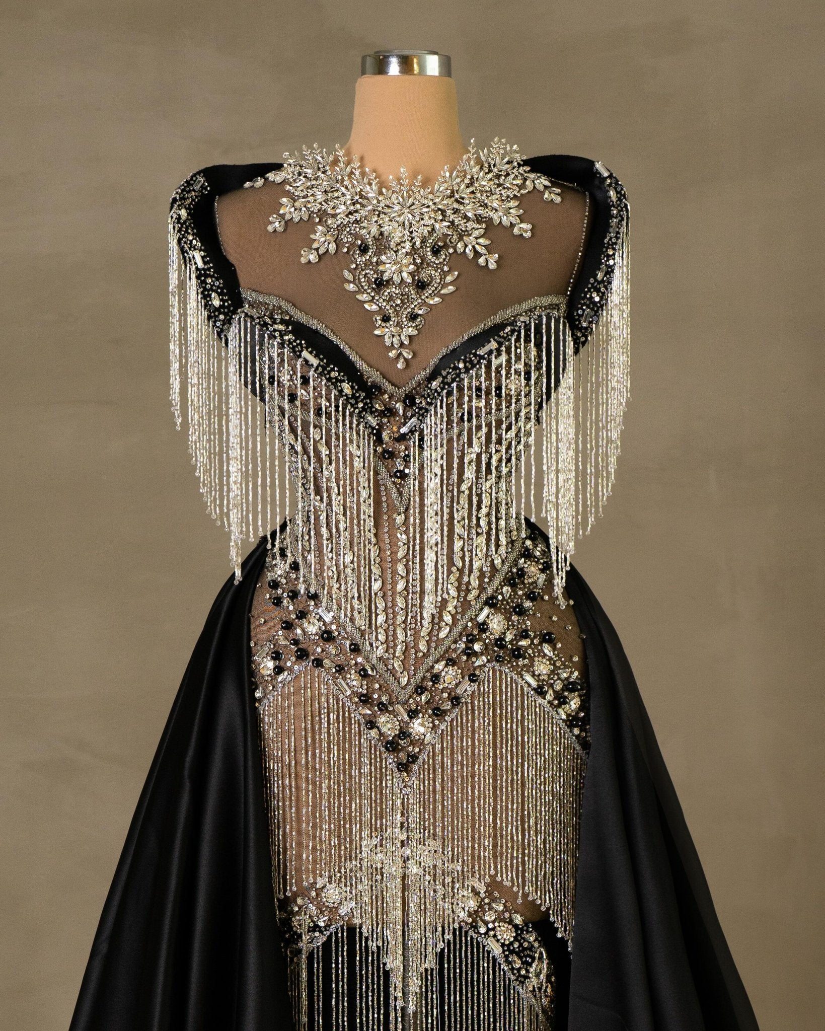 Close-up of Black Long Dress with royal wings, silver and black stones, crystals, and delicate tassels