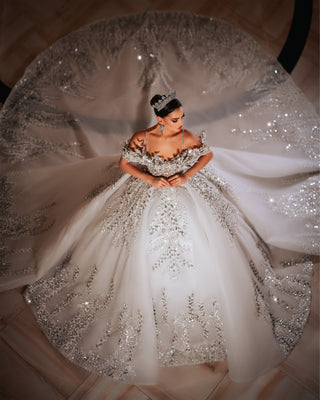 Exquisite bridal gown showcasing off-shoulder style and intricate lace detailing for a timeless look.