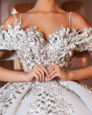 Close-up of luxurious lace and crystal embellishments on a stunning bridal gown, adding elegance and sparkle.
