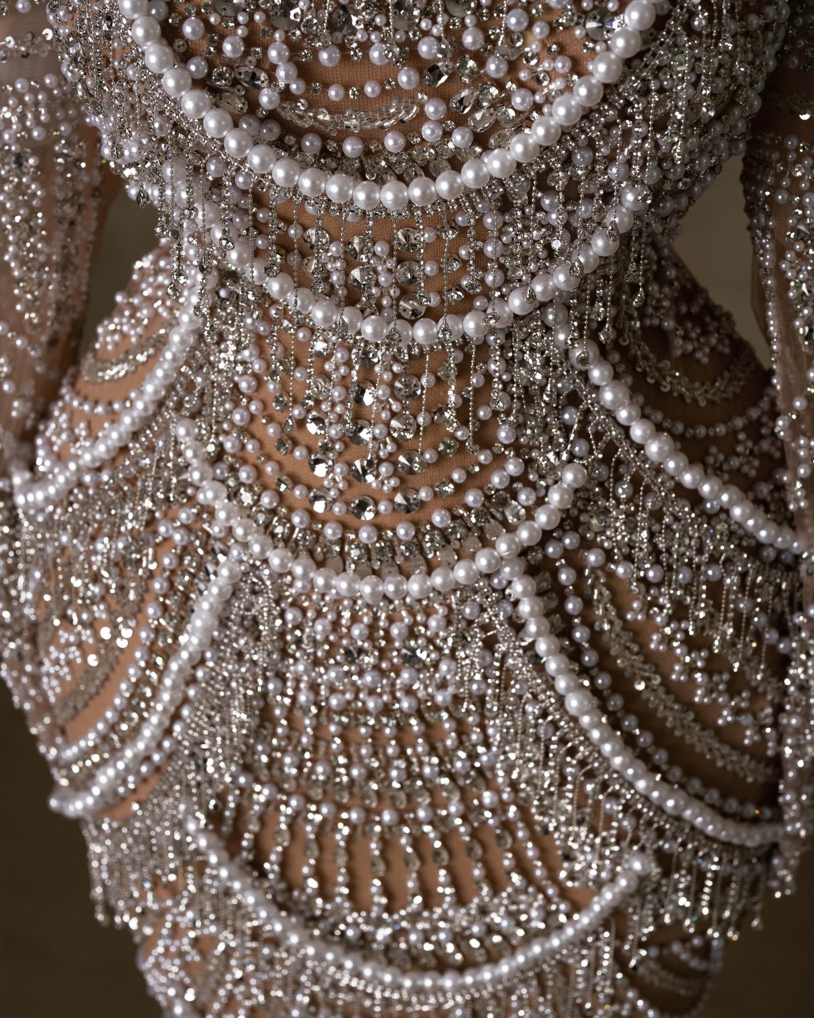 Bridal gown featuring lace, stones, and pearls.