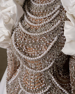 Details of bridal gown featuring lace, stones, and pearls.