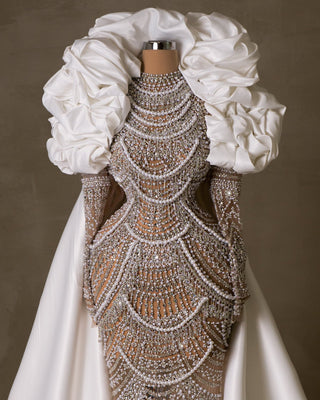 Elegant lace bridal dress adorned with pearls and stones.