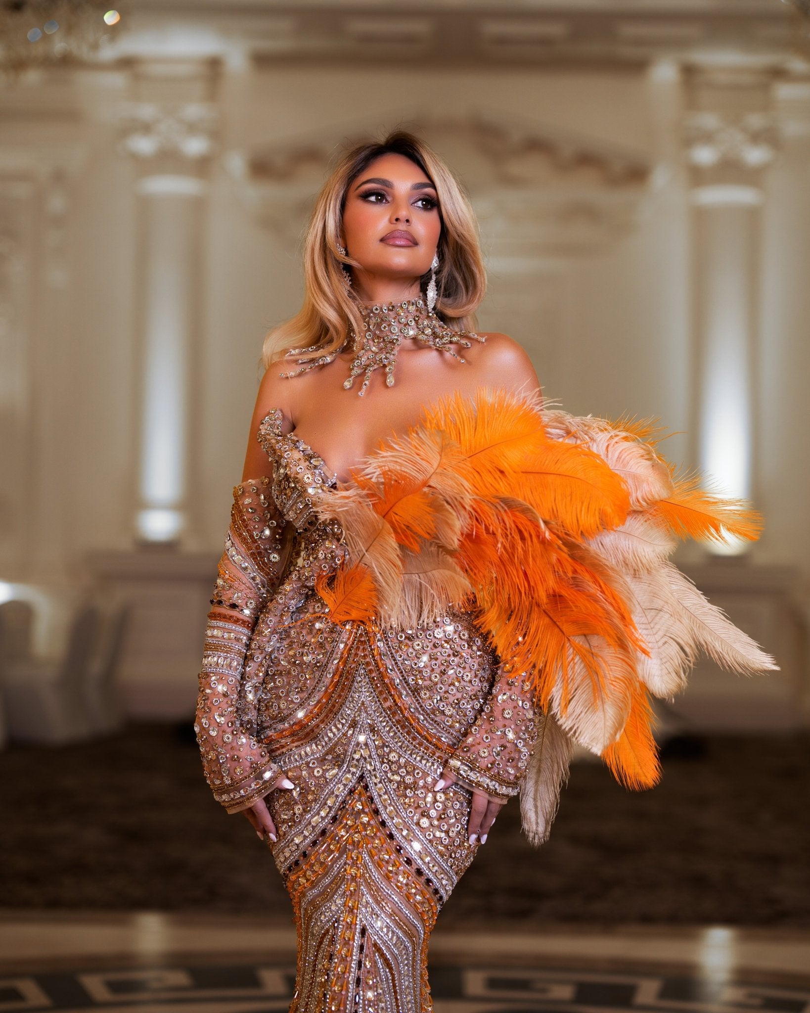 Long lace dress adorned with silver, gold, and orange crystals.