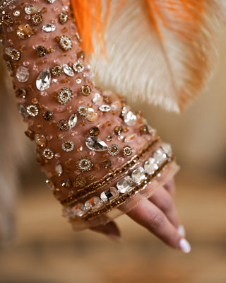 Orange gown adorned with shimmering crystals.